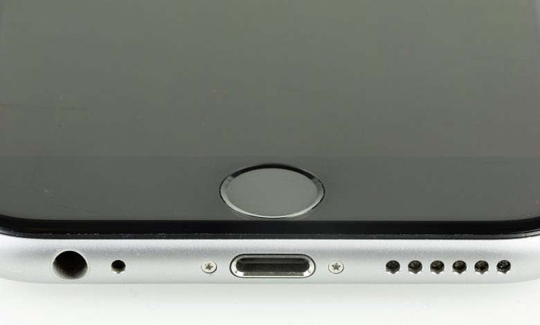 A person unlocking a smartphone with a fingerprint